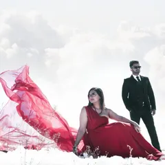 A highly stylized and dramatic portrait in the snow. This image showcases a more editorial approach, creating a high-fashion look that feels like it's straight out of a magazine while still telling their unique love story.