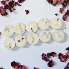 A wider view of a set of ten rose petal tealights, surrounded by loose, dried rose petals to show the natural ingredients I use.