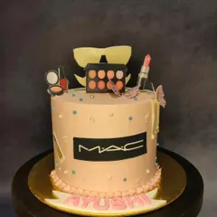 A cake for the makeup lover, themed around MAC Cosmetics. This cake is topped with edible replicas of lipstick, eyeshadow palettes, and nail polish, all crafted with precision.