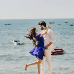 A breezy, romantic moment on the shores of Goa. The wind catching her hair and dress as they embrace by the sea creates a feeling of effortless, natural love.