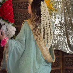 The back view of this beautiful hairstyle created for a pre-wedding look. The long, flowing curls are adorned with a cascade of fresh jasmine flowers (gajra), creating a traditional and fragrant style.