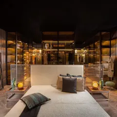 A view of how our innovative wardrobe solutions can define a bedroom. The glass island wardrobe creates a visual connection between the sleeping area and the walk-in closet, resulting in a spacious and integrated master suite.