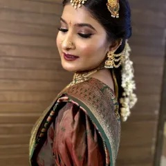 A close-up shot of this South Indian bride's look, focusing on the rich, warm tones of her makeup. The deep lipstick and defined eyes are perfectly coordinated with her silk saree and temple jewelry.