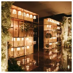 A breathtaking entrance designed for a sangeet with the theme 'Elegance in Simplicity'. A grand arch of baby's breath and white roses welcomes guests into a hall filled with the soft glow of custom lamps and chandeliers.