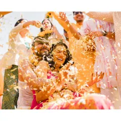 A shower of love and petals for the happy couple. This action shot, full of movement and joy, perfectly captures the high energy and celebratory spirit of their sunflower-themed Haldi.