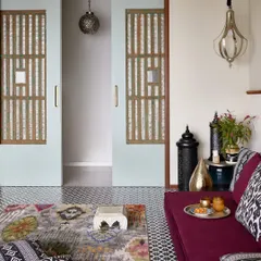 This versatile family room is designed for connection and reflection. The large sliding doors are the centerpiece, crafted from old Portuguese Goan shell panels that filter light beautifully. By repurposing these historic elements, we’ve woven a piece of Goan architectural heritage into a modern Mumbai home.