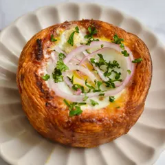 Our Patatas Bravas Puff Galette, a savory creation from our Spanish pop-up. It features a perfectly baked egg nestled in a flaky puff pastry crust.