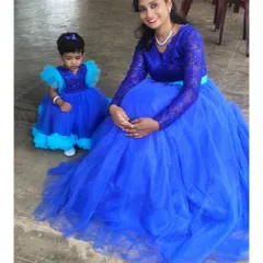 This royal blue gown set was designed for a client and her little one. The mother's dress has delicate lace sleeves, and the daughter's frock features fun, contrasting light blue ruffles.