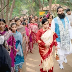Leading the way with grace and purpose. Mahayogi Madhucarji and Maa Aditiji walk with students at a spiritual event, demonstrating that the path of mindfulness is a journey we take together as a community.