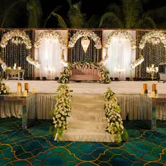 An elegant reception stage designed with classic white florals, cascading fairy lights, and warm candlelight. This setup is perfect for a sophisticated evening, creating a romantic and timeless atmosphere.