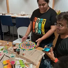 An instructor guiding a student during a Lippan art workshop. We provide personalized attention to ensure everyone learns the technique and leaves with a piece they are proud of.