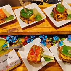 A beautifully arranged platter of our Stuffed Paneer Tikka appetizers. Each piece is individually plated and garnished with fresh mint and a wedge of lime, showcasing our attention to detail even for passed snacks.