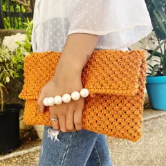 Style meets craftsmanship in this macramé clutch bag. I designed it to be a versatile accessory, perfect for both casual outings and special occasions. The intricate knotting is paired with an elegant pearl handle, creating a statement piece that is both beautiful and functional.