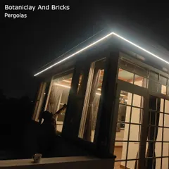 The beauty of integrated lighting on a pergola. This night shot shows how a simple LED strip light can outline the structure, providing functional illumination and creating a sleek, modern aesthetic for this enclosed glass patio.
