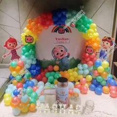 Another look at a Cocomelon party setup, showcasing the full stage with a custom backdrop, balloon arch, and themed cake stands.