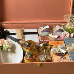 This premium hamper, presented in an elegant pink trunk box, is filled with luxury items like a marble-patterned tray, gourmet cookies, and scented candles. It’s designed for those moments that call for an extra touch of class and sophistication.