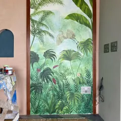 We call this our tropical paradise. We transformed the walls of a restaurant with a misty forest theme, covering even the doors to create a seamless, immersive jungle experience with colorful birds and lush greenery.