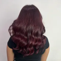 For those who love a bold statement, this deep burgundy global color is a showstopper. We finished the look with a layered cut and bouncy waves to add movement and make the rich color pop.