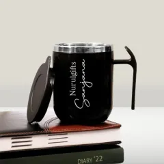 This personalized stainless steel coffee mug comes with a lid and can be engraved with a name, making it a great addition to any desk.