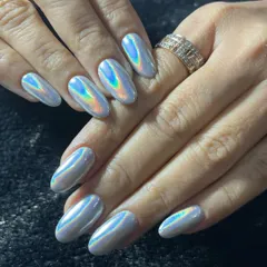 I love keeping up with the latest trends, and holographic chrome is a client favorite. These almond-shaped nail extensions have a smooth, mirror-like finish that catches the light and shifts through a rainbow of colors.