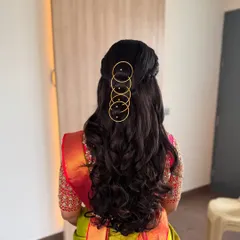 A chic and modern hairstyle featuring soft waves and a unique gold ring accessory. This is a great option for a contemporary pre-wedding or reception look.