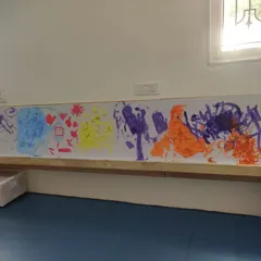 The finished mural is a vibrant testament to their teamwork and individual expression. This abstract piece showcases a variety of colors and brushstrokes, capturing the energy of the session.