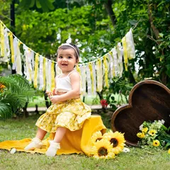 A sunny first birthday in a field of sunflowers. This outdoor setup is perfect for a nature-loving family, creating bright and cheerful portraits.