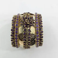 This unique purple and gold bangle set combines silk thread with oxidised coins and a central floral kundan piece. It's a statement design for brides who want something bold and traditional.