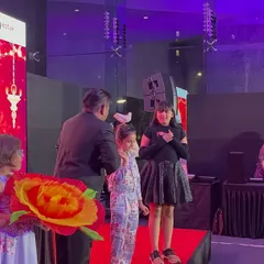 At a corporate Diwali Milan event, I invited some kids on stage to help with a grand illusion. Using large, colourful props like this giant flower makes the magic visible and exciting for everyone in the audience.
