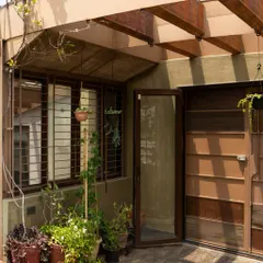 The transition from an indoor space to the terrace garden. The use of natural materials like wood for the pergola and door frames helps to create a seamless flow between the built environment and the green space outside.