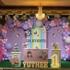 This is a full-stage butterfly theme I designed for a first birthday. It features a large pastel balloon garland, custom-painted backdrops, light-up marquee numbers, and themed props like the giant pink butterfly wings for a perfect photo opportunity.