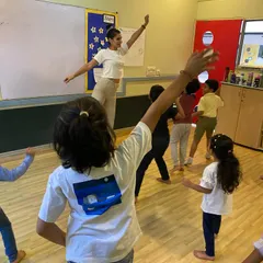 Leading by example with a physical warm-up. Movement is a key part of our process, helping children connect with their bodies, release energy, and prepare their minds for creative work.