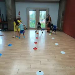 Rain can't stop our fun! When we move indoors, we switch to different games that keep the energy high. Here, we're working on hand-eye coordination with a fun hockey-style drill, learning to control the ball and aim for the target.