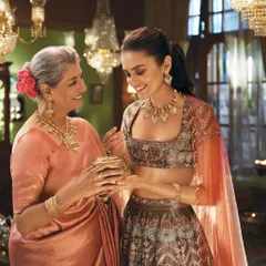 This shot from the Tanishq 'Dharohar' campaign tells a story of heritage passed down through generations. The styling connects a mother and daughter through coordinated color palettes and traditional jewellery, creating a moment of warmth and connection.