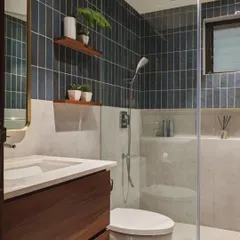 Here is the same bathroom layout, but with a different mood. The dark, vertically stacked tiles create a more sophisticated and dramatic look. The light-colored lower walls and floor keep the space from feeling too heavy.