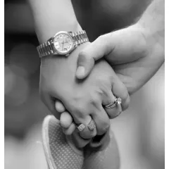 This black and white shot focuses on the details, showing a parent's hands gently holding their baby's tiny feet. It's a symbolic photo of protection and love.