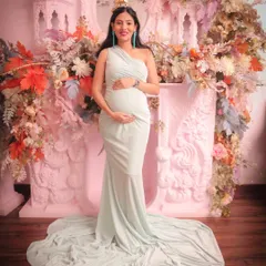 Celebrating the mom-to-be with a dreamy, pastel-themed backdrop. This setup features a custom-designed pink fireplace prop overflowing with delicate flowers, creating a soft and elegant setting for a maternity shoot.