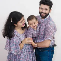 A happy family of three in matching printed outfits. Coordinated clothing can make for beautiful and memorable family portraits, and we capture the joy of these moments.