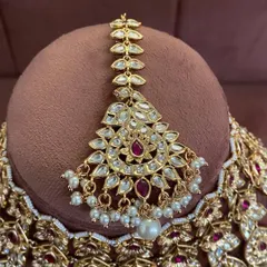 A close-up of the maang tikka from the modern ruby choker set. The design is delicate yet makes a statement.