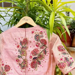 The back of the pink Kalamkari patchwork blouse, displaying the full expanse of the intricate floral embroidery. The delicate beadwork scattered across the fabric adds a subtle shimmer to the piece.