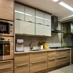 A beautiful combination of light wood grain and glossy grey cabinets. This kitchen design feels modern and warm, with integrated stainless steel appliances completing the look.