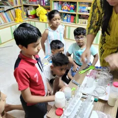 I love seeing kids this focused and curious. Here, a group is gathered around the table, carefully observing a chemical reaction. My goal is to create these moments where they are completely absorbed in the process of discovery.
