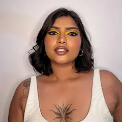 A bold and sunny look featuring a bright yellow graphic eyeliner. This is a perfect example of how to play with color in a modern and chic way.