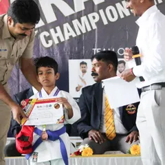 A young champion receives his medal and certificate at our inter-school karate championship. We believe in recognizing effort and achievement to motivate our students on their martial arts journey.