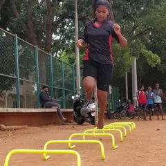 Look at the focus and power. This is one of our female athletes mastering a hurdle drill to improve her footwork and speed. We train our athletes to be explosive and agile, which is crucial for competitive sports.