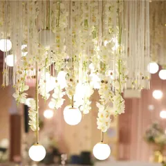 A close-up of the delicate lighting from our 'Midsummer Dream' theme. Cascading white orchids are intertwined with glowing globe lights, creating an ethereal and romantic effect that transforms the entire space.