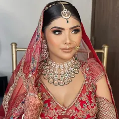 A close-up of a bride wearing a beautiful Kundan choker with green stone accents. This type of necklace is a versatile choice that complements many different bridal outfits.