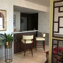 We integrated a compact and stylish home bar into this residence. The design features fluted wood paneling and a marble countertop, complemented by elegant bar stools to create a dedicated space for entertaining.