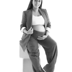 This powerful black and white portrait showcases a modern and confident style. The combination of a blazer and exposed baby bump creates a striking image that is both raw and timeless.