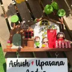 A complete family portrait on a nameplate. This custom piece includes figurines for the parents and their child, making it a heartwarming welcome for guests and a daily reminder of family love.